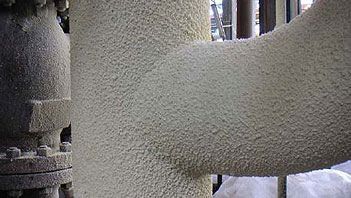 Hot pipe coating system applied to industrial storage tanks for thermal insulation and corrosion protection